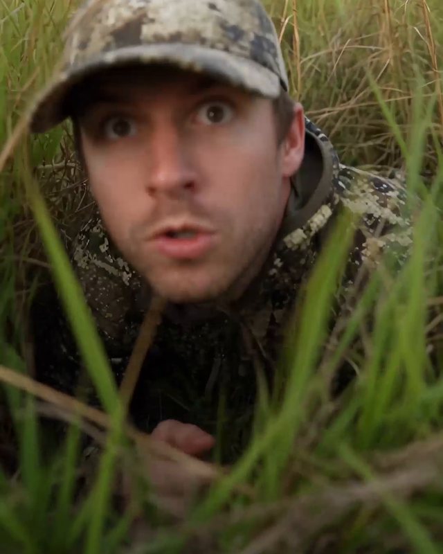 Man in camouflage hiding in the grass